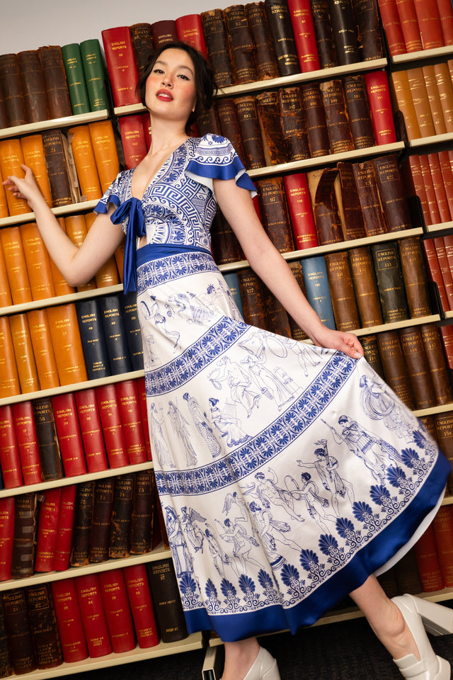 Woman of Leisure Rio Maxi Dress front full length view showing blue and white maxi dress with flutter sleeves, tie front detail and Grecian inspired print
